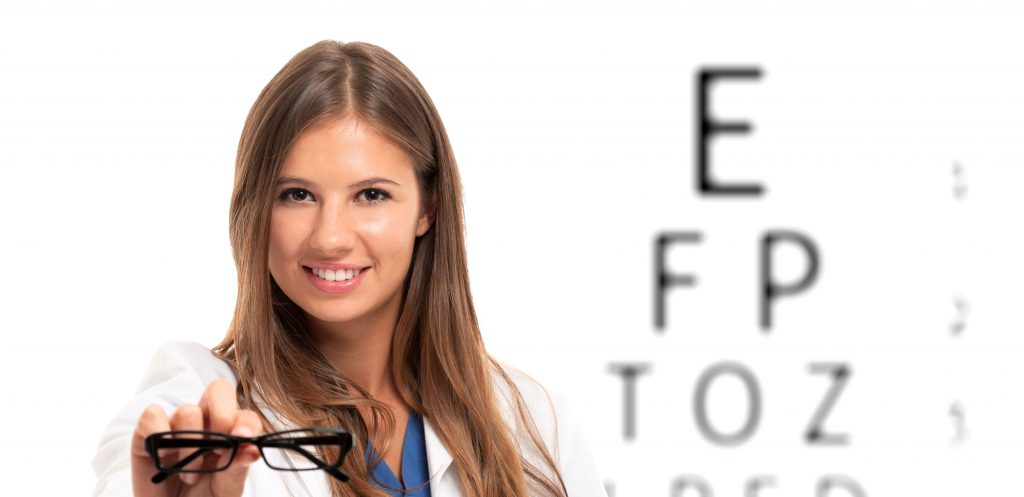 woman holding glasses in front of blurry eye chart