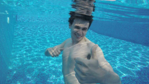 man showing thumbs up under water
