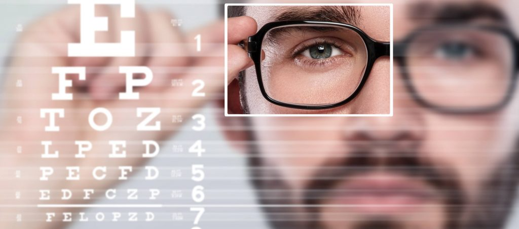 man in glasses looking at eye chart