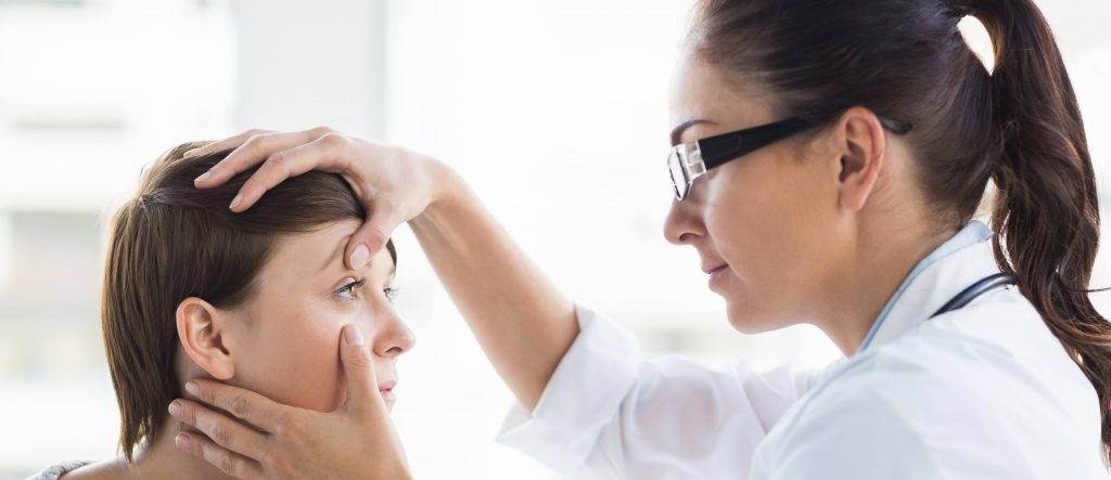 Eye care doctor looking at person's eyes