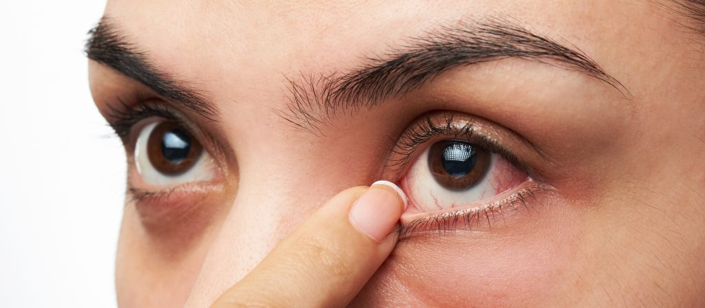 woman opening eye with her finger