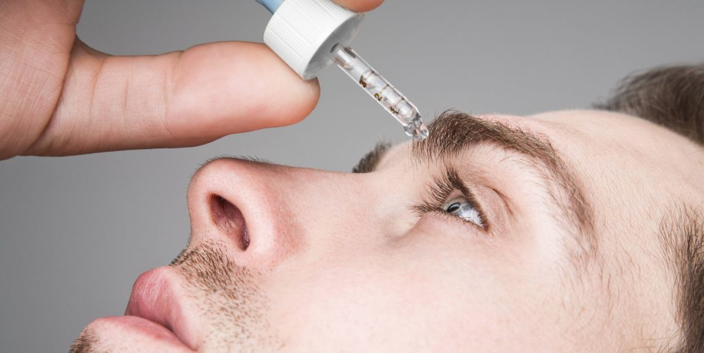 man putting in eye drops