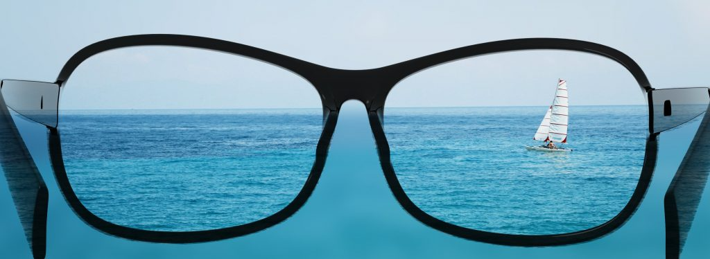 glasses looking at sailboat in the ocean