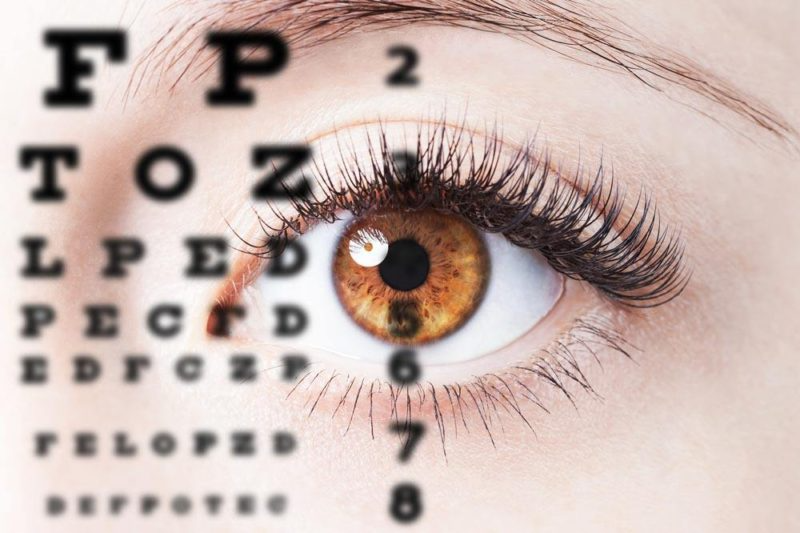 close up of woman's brown eye looking at eye chart