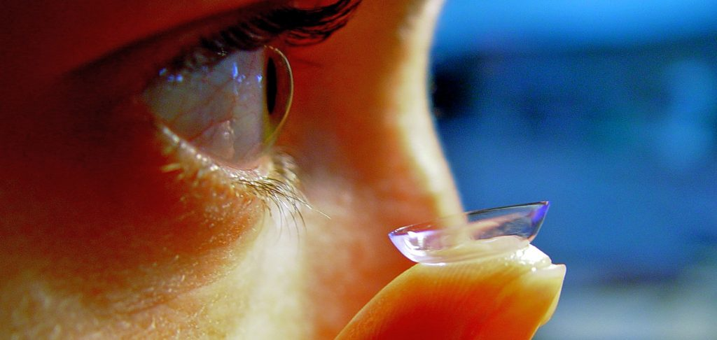 woman putting in contact lens