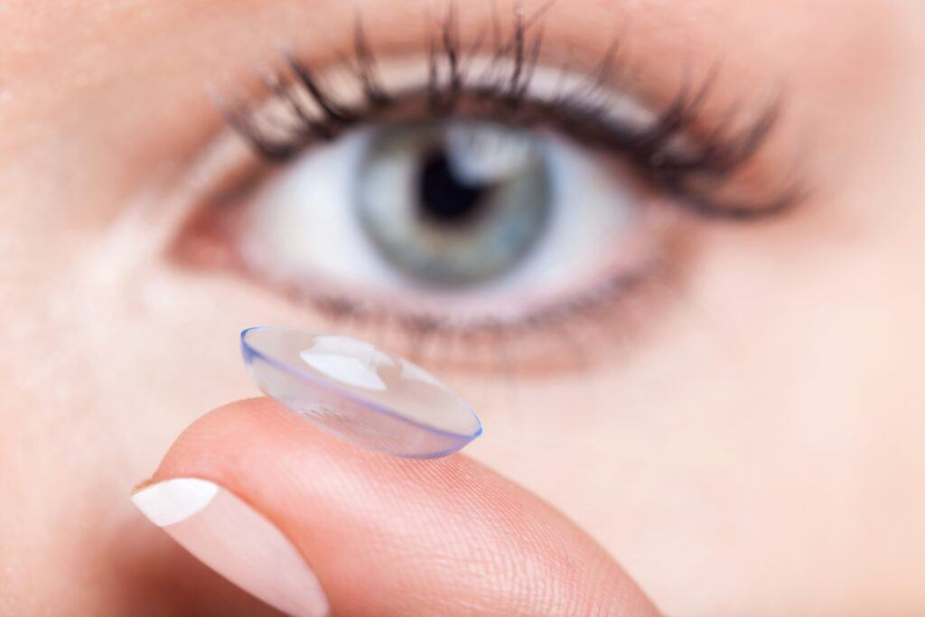 woman eye with contact lens applying contacts