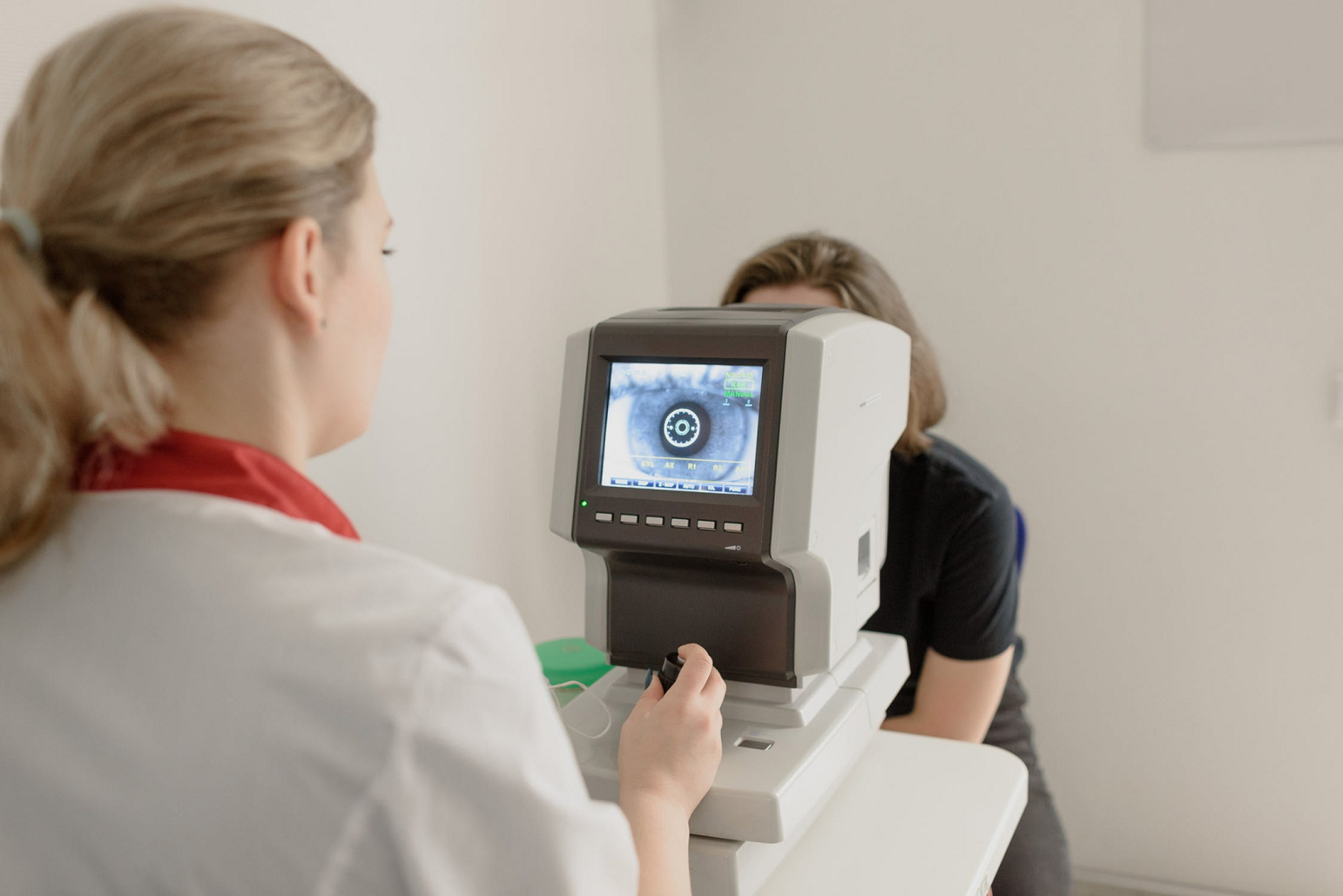 ophthalmologist checking eyesight of woman on vision screener