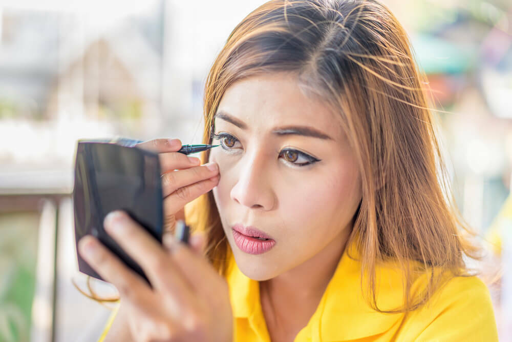 Woman doing her eye makeup