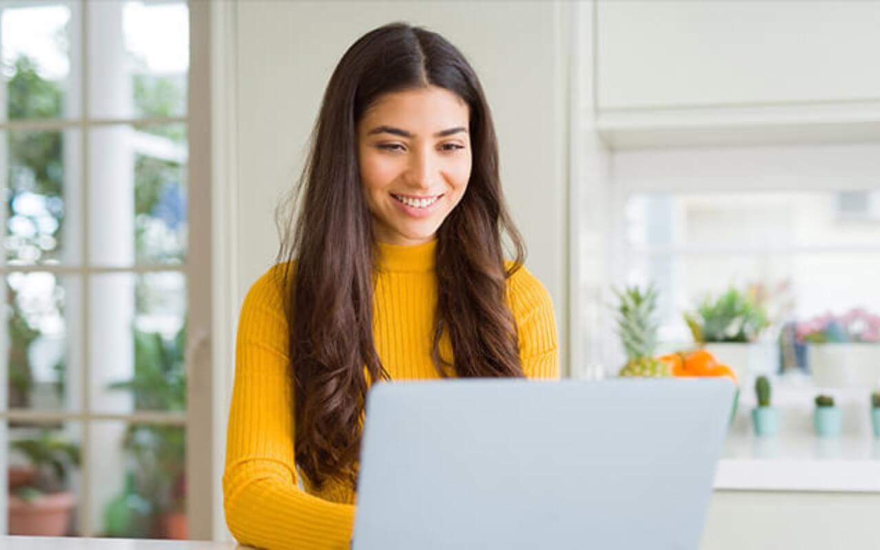 smiling woman checking dlv vision lasik prices on a computer