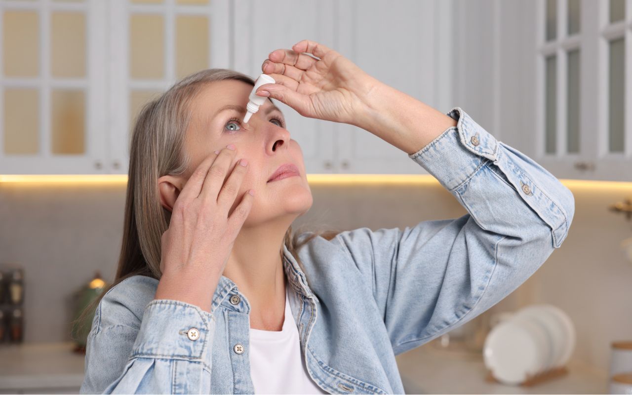 elderly woman using eye drops