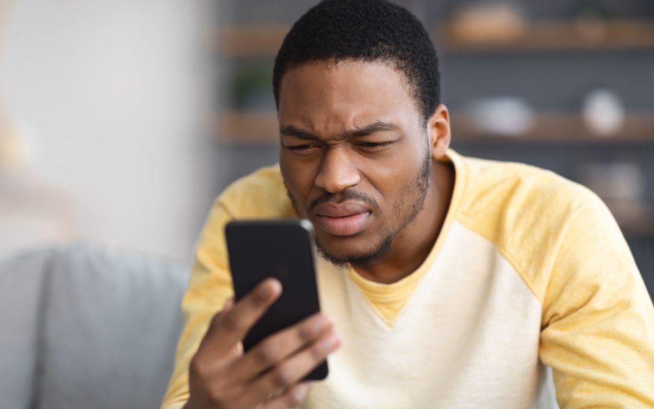 man squinting at his phone 
