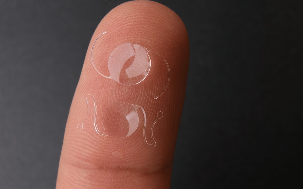 Intraocular lenses on someone's fingertip. 